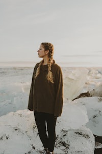 a woman standing on top of icebergs in iceland