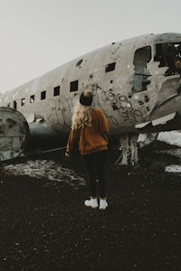 a woman standing in front of an old airplane