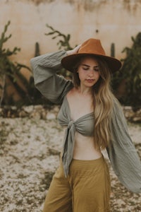 a woman wearing a hat and khaki pants