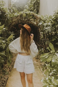 a woman wearing white shorts and a hat